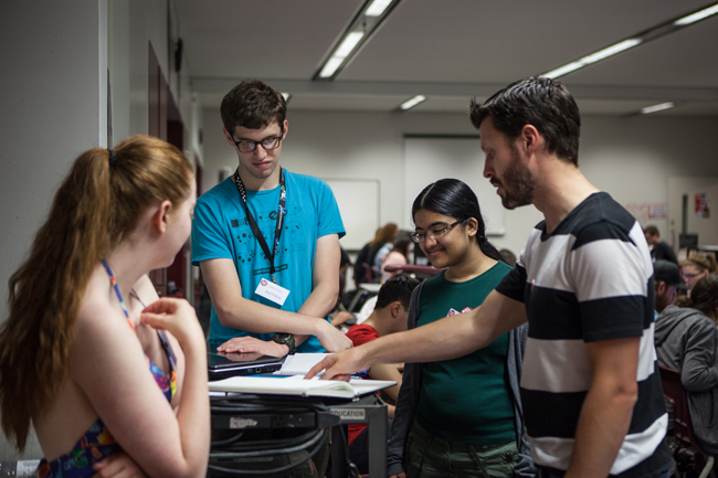 A ROM Gallery Coordinator answers dinosaur questions for three Game Jam participants