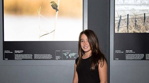 Young finalist Laura Albiac (Spain) and her photo at the WPY exhibit at the London Natural History Museum. Photo courtesy of the Trustees of the NHM London