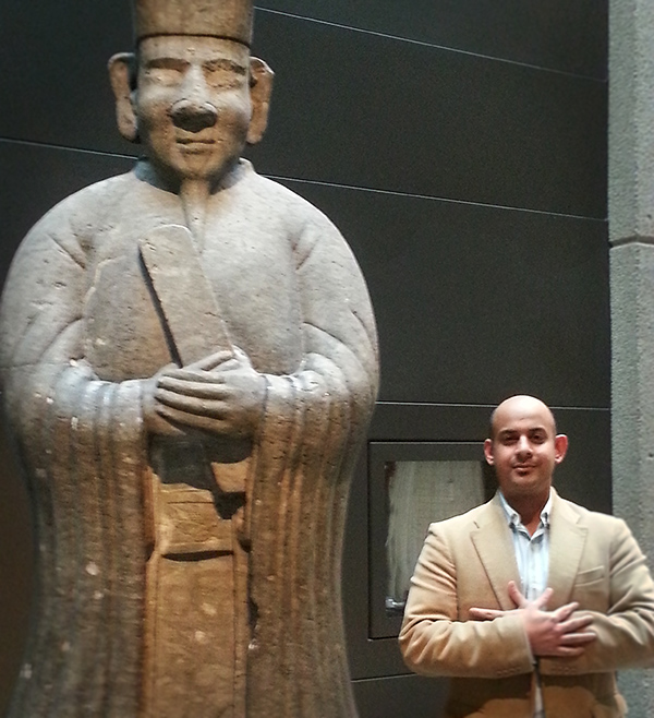 Visitors to the ROM pose beside a lime stone statues stand in the Gallery of China on Level 1