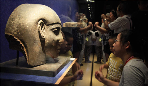 Photo of visitors looking at an Egyptian object