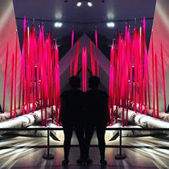 Photo of two people standing in front of a glass art piece
