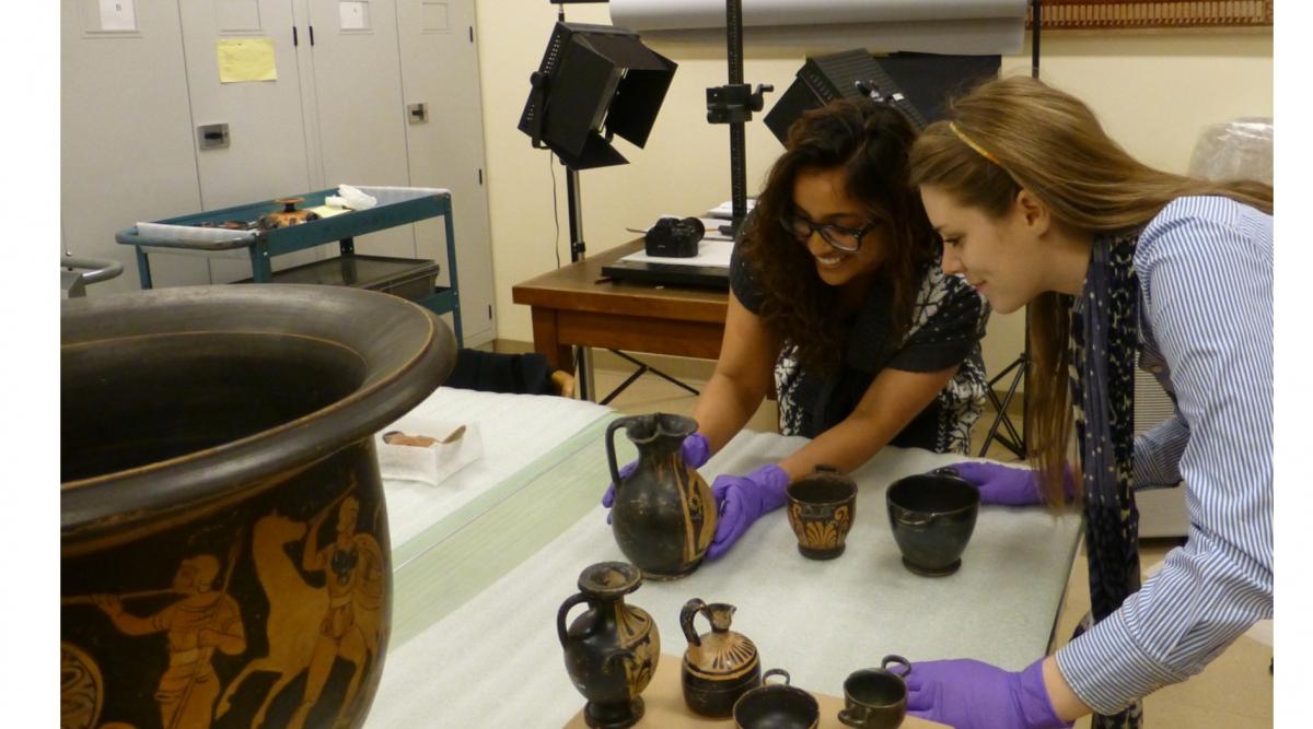 Natasha Ali & Lindsay Britton examining ancient artifacts