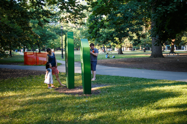 A family with a young child peer at the Trees Toronto identification kiosk in Queen's Park. Photo by Rhi More
