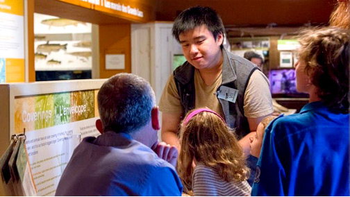 Volunteer speaking to a group of visitors in the Hands On Gallery