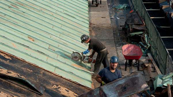Man cutting copper roof