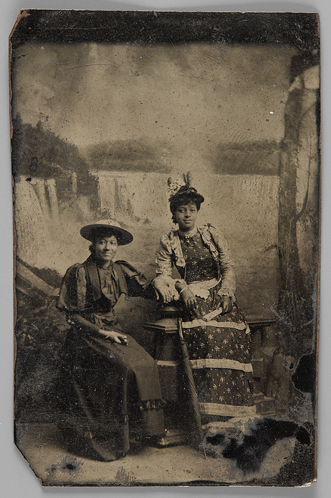 Black and white photo of two women sitting in front of Niagara Falls
