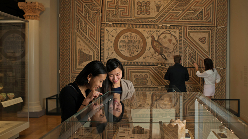 Two young women looking at display case.