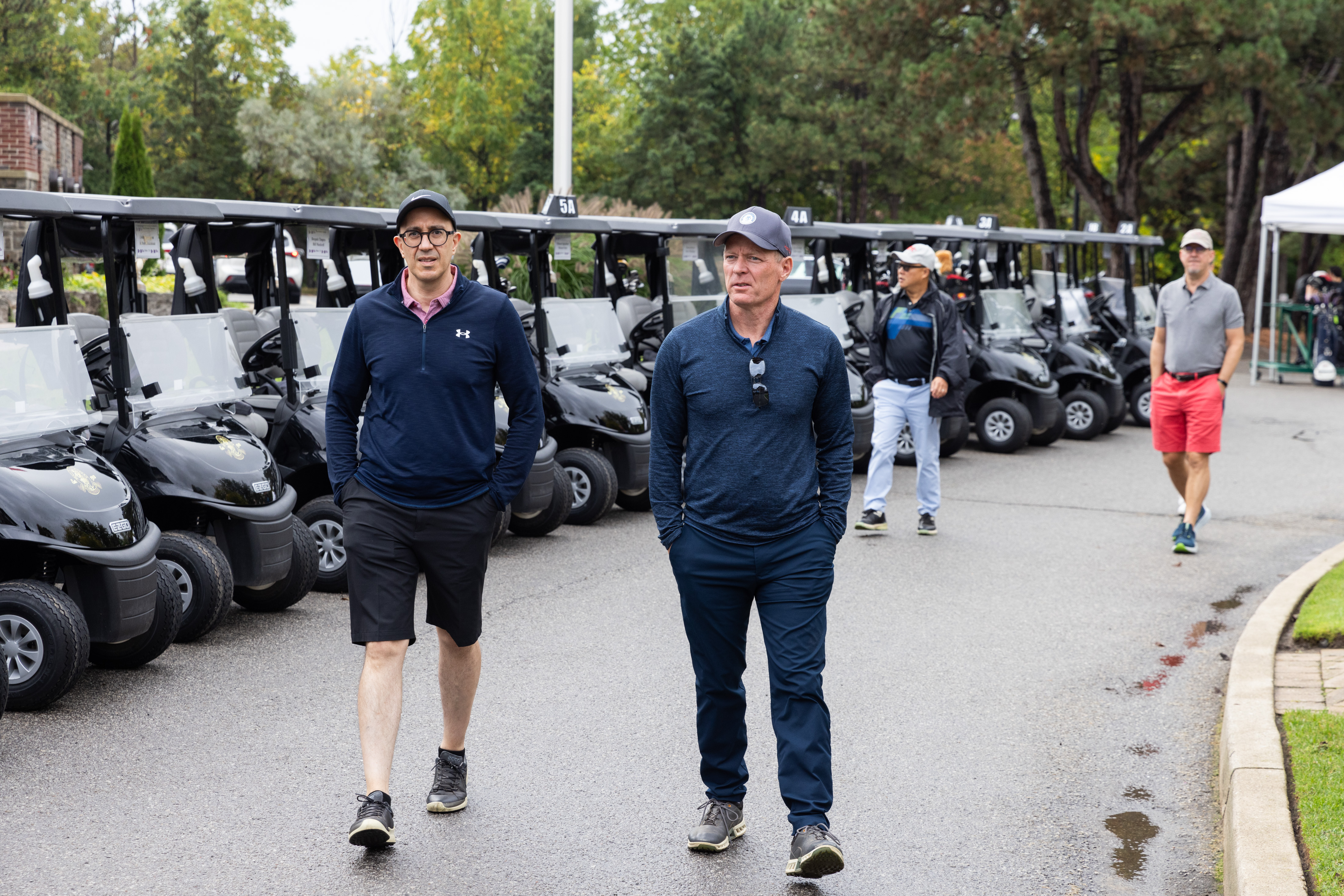 Two male golfers walking to the golf course