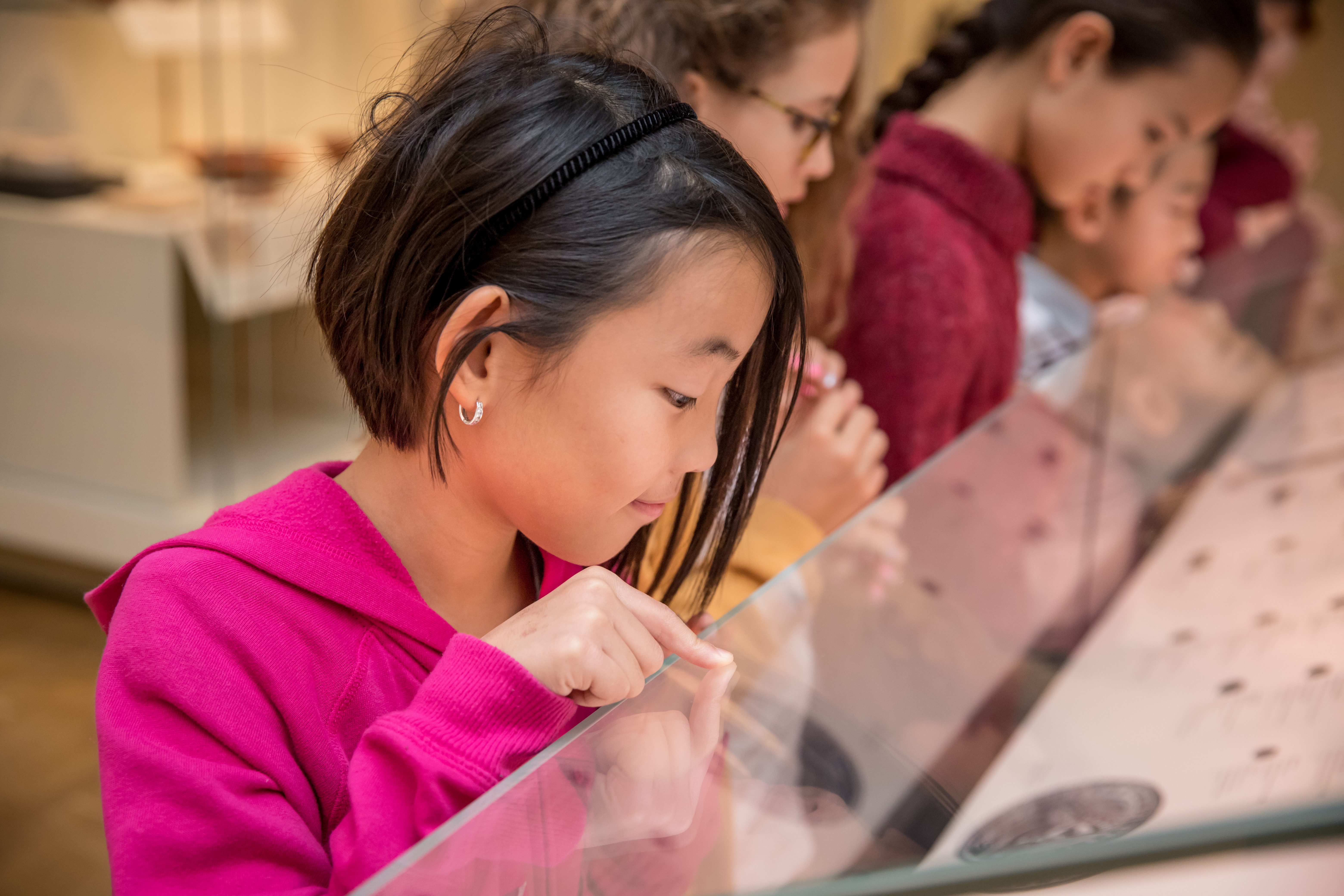 A child looks at a display case and points to something inside