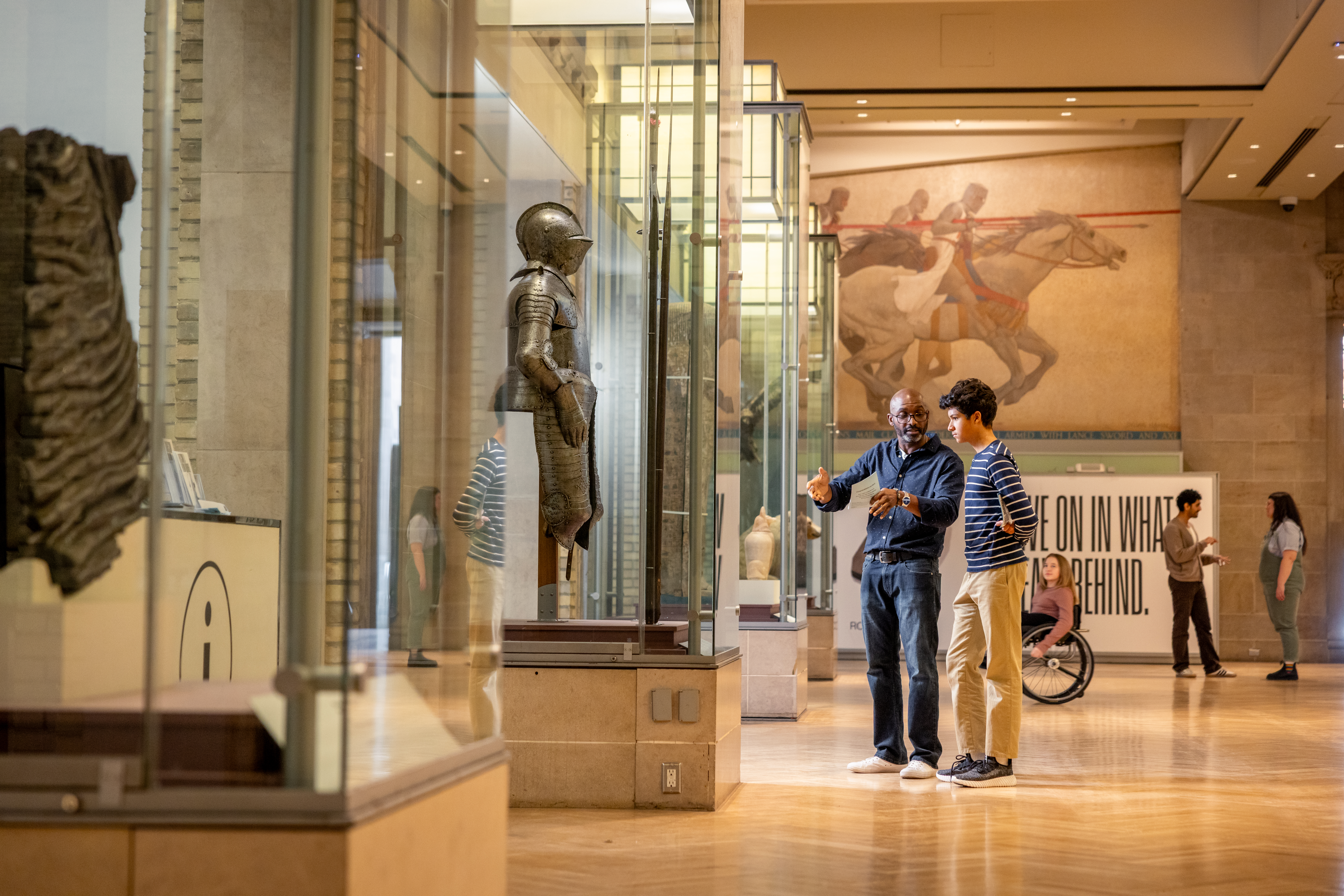 Two people looking and discussing a case of a knife in Currelly gallery