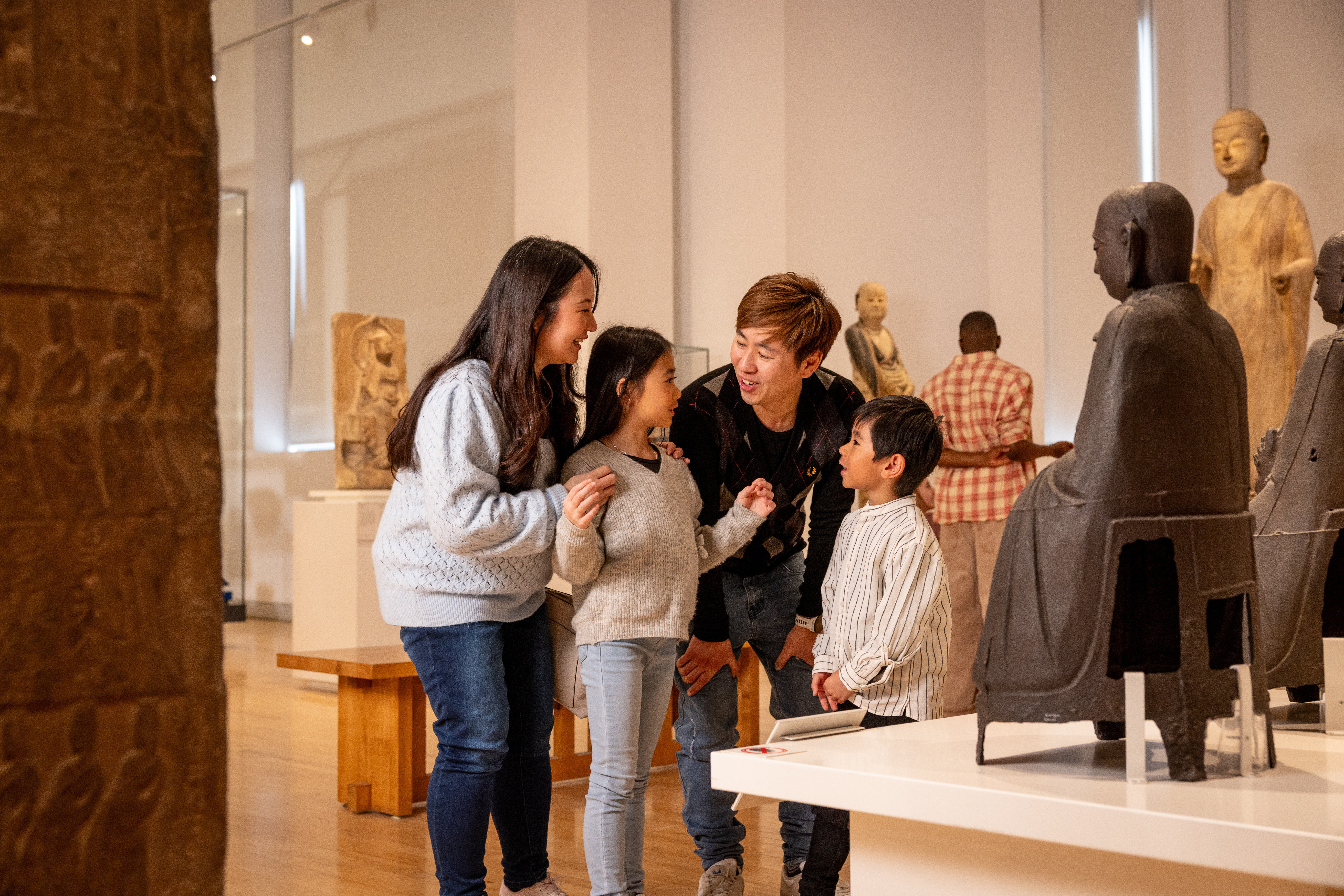 Family of four looking at object in China Gallery