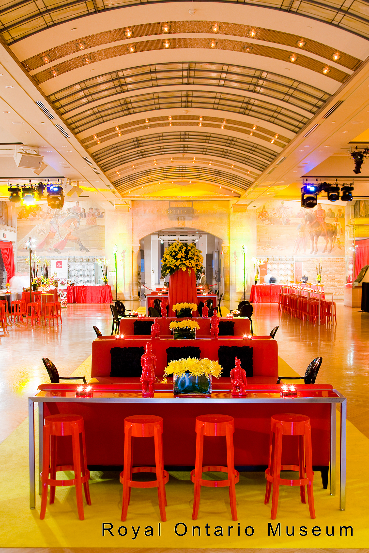 A room filled with red chairs and tables in the Currely Gallery of Royal Ontario Museum.