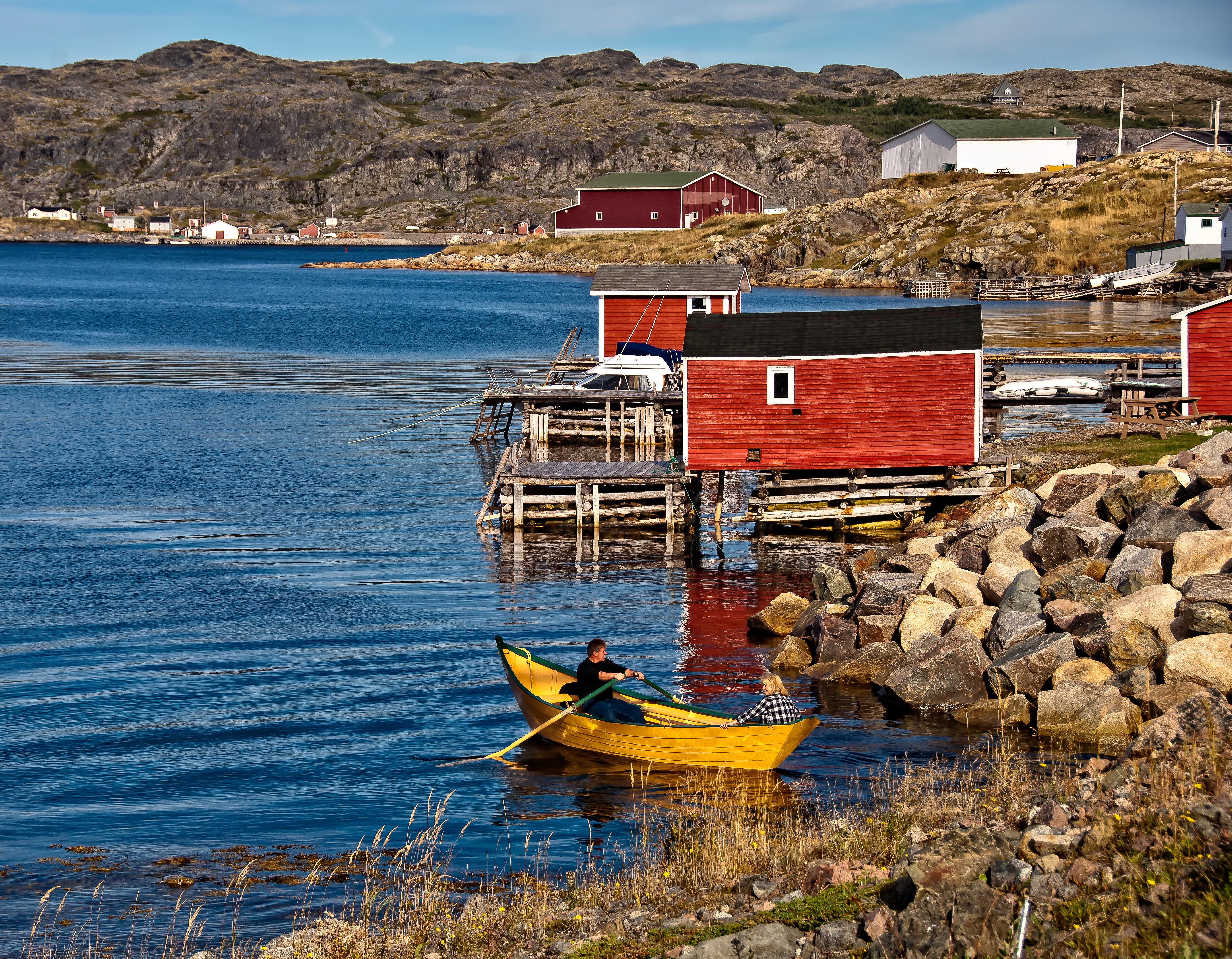 Colourful houses by the seacoast with a rowboat in the foreground.