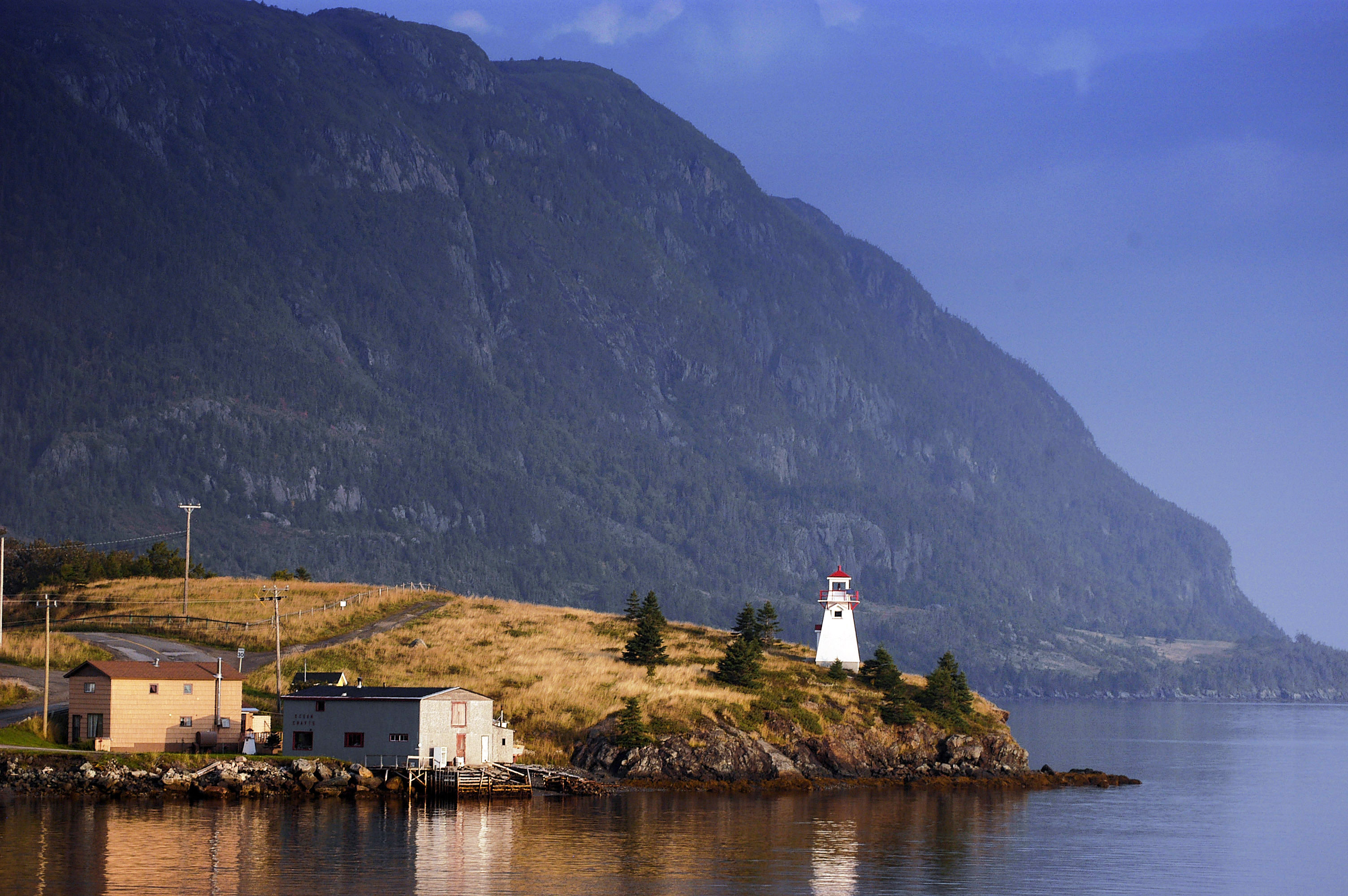 A lighthouse with a mountain in the background.