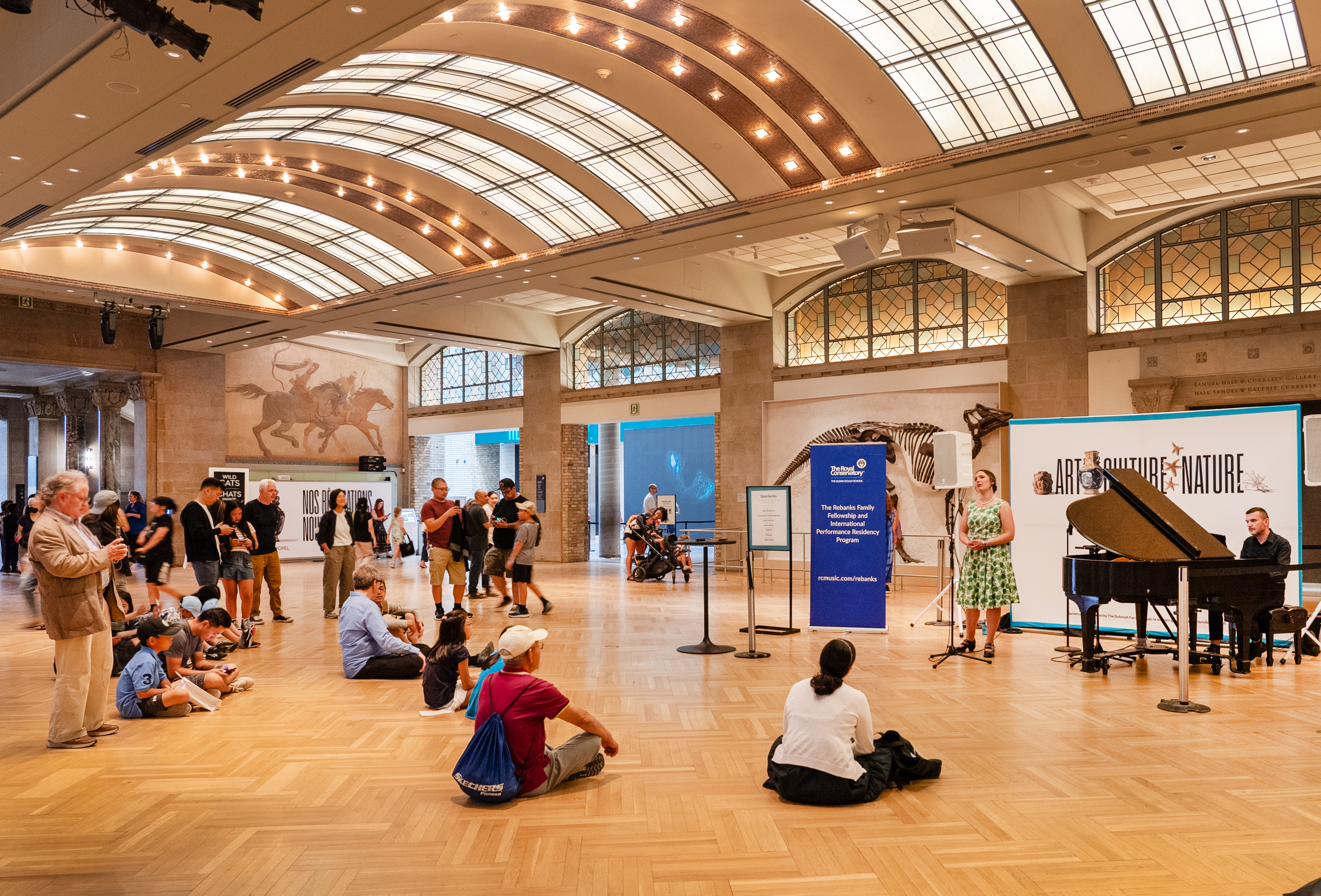 Gathering around a performance on the main floor at the Royal Ontario Museum. 