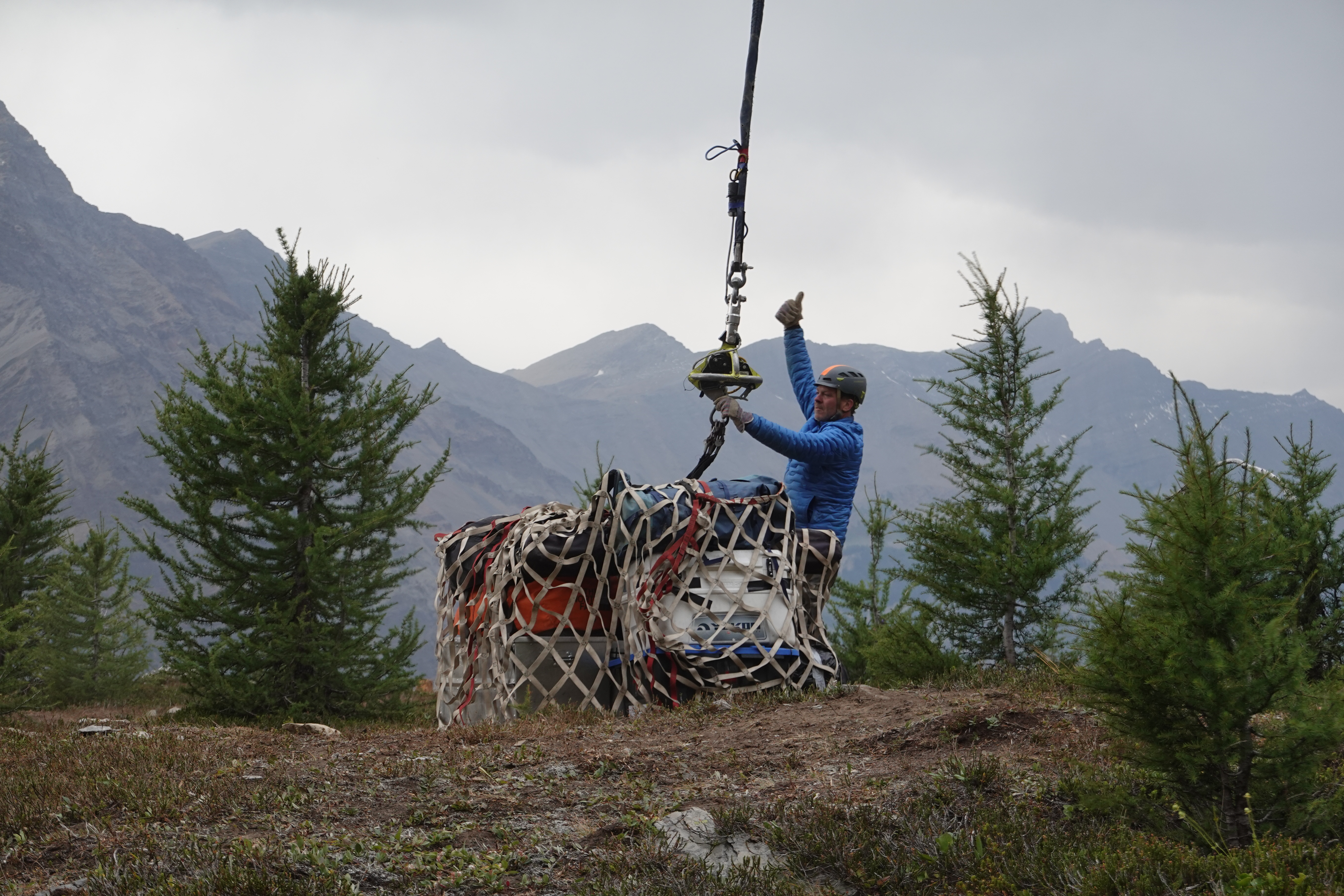 Crates being lifted by helicopter.