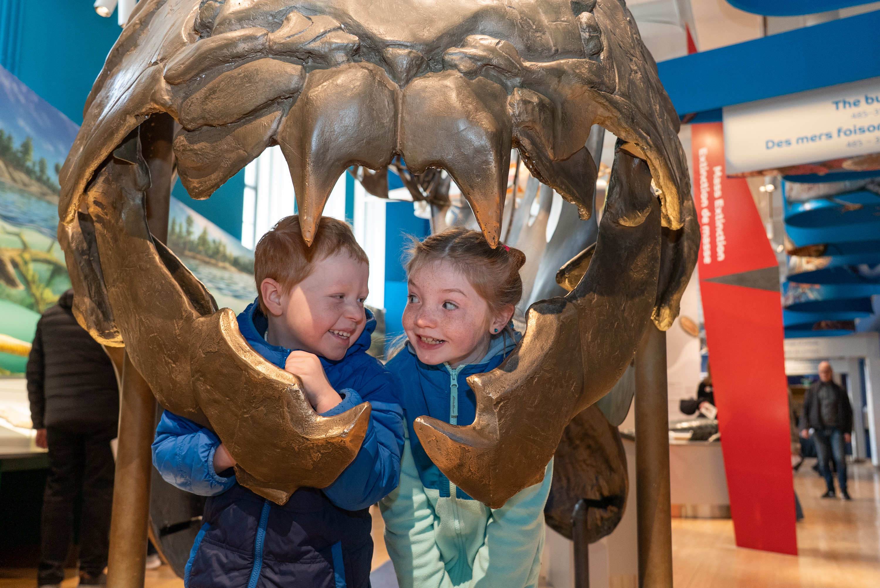 Two children look out from the mouth of the Dunkleosteus in the Dawn of Life Gallery