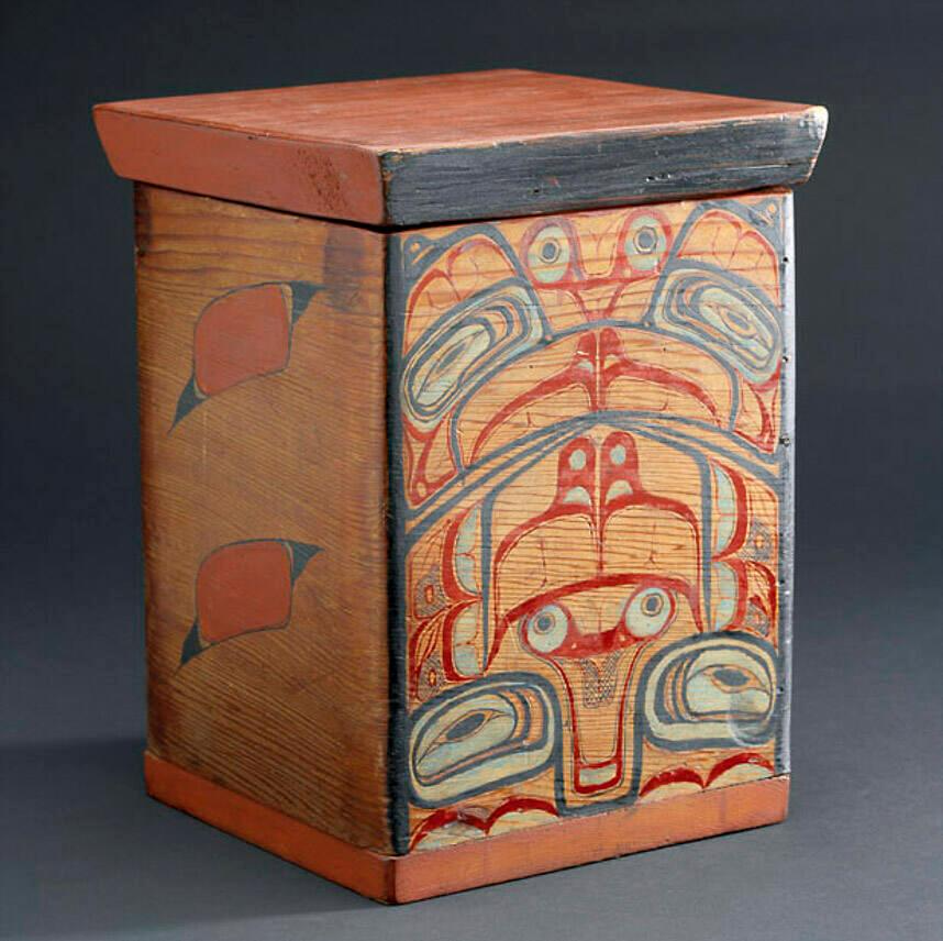 A box made of red wood painted in designs of red, black, and white.