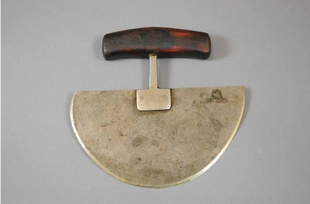 A knife with a metal blade shaped as a semi-circle, connected to a wooden handle.