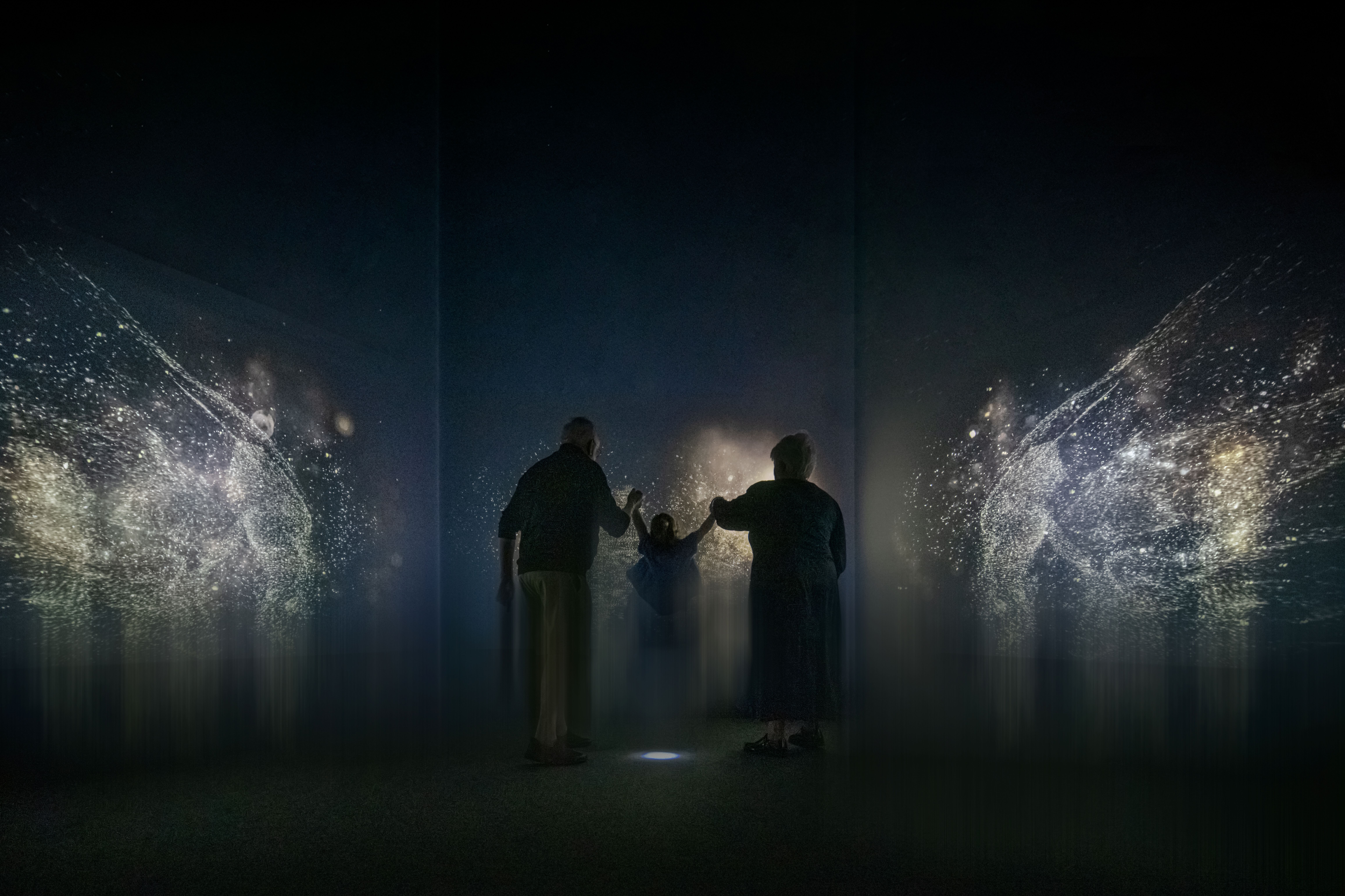 Two adults and a child experiencing the immersive exhibition.