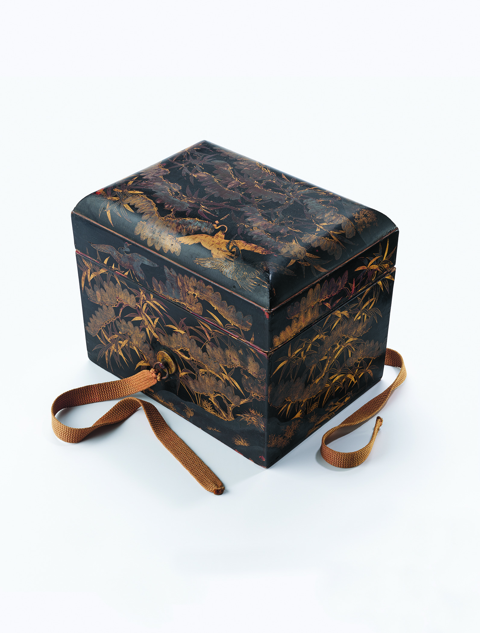 Rectangular black lacquer box decorated with intricate gold illustrations of birds, grasses, and foliage on the lid and sides, with two brown cord ties attached, photographed on a white background with soft, even lighting. 