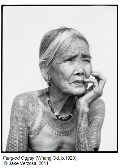 Fang-od Oggay (Whang Od), born circa 1920, with traditional tattoos on her shoulder and chest, resting her chin on her hand.