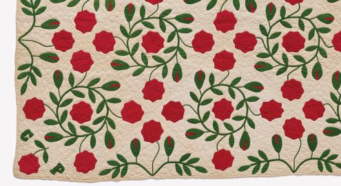 Quilt avec un motif de fleurs rouges et de feuilles vertes sur un fond crème.