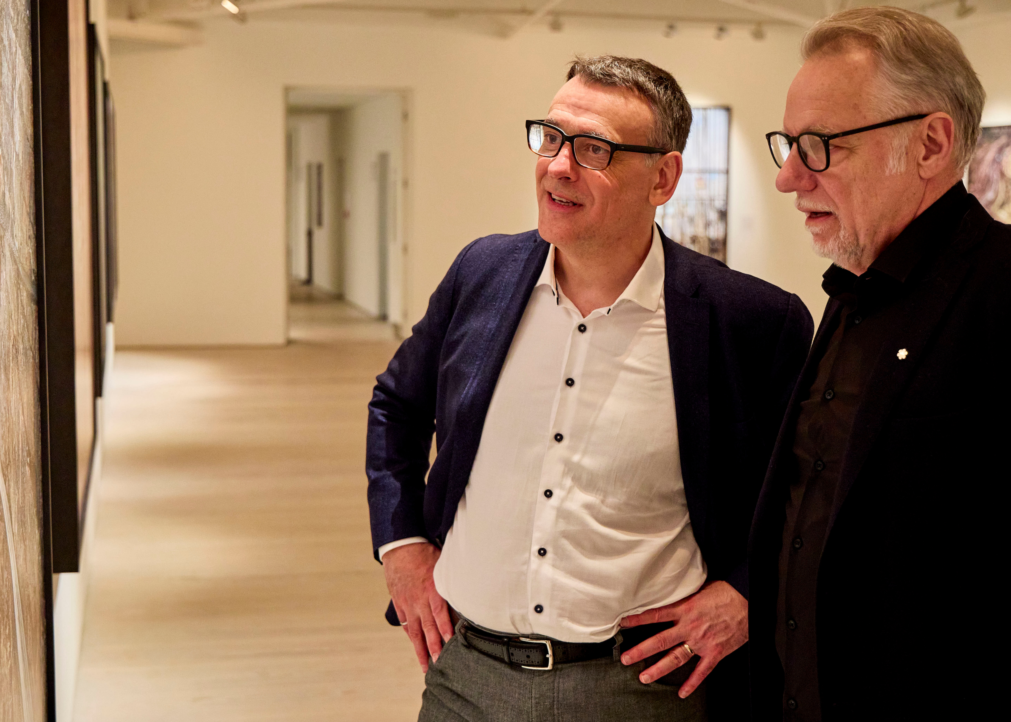 John Bianchini and Edward Burtynsky looking at artwork. 