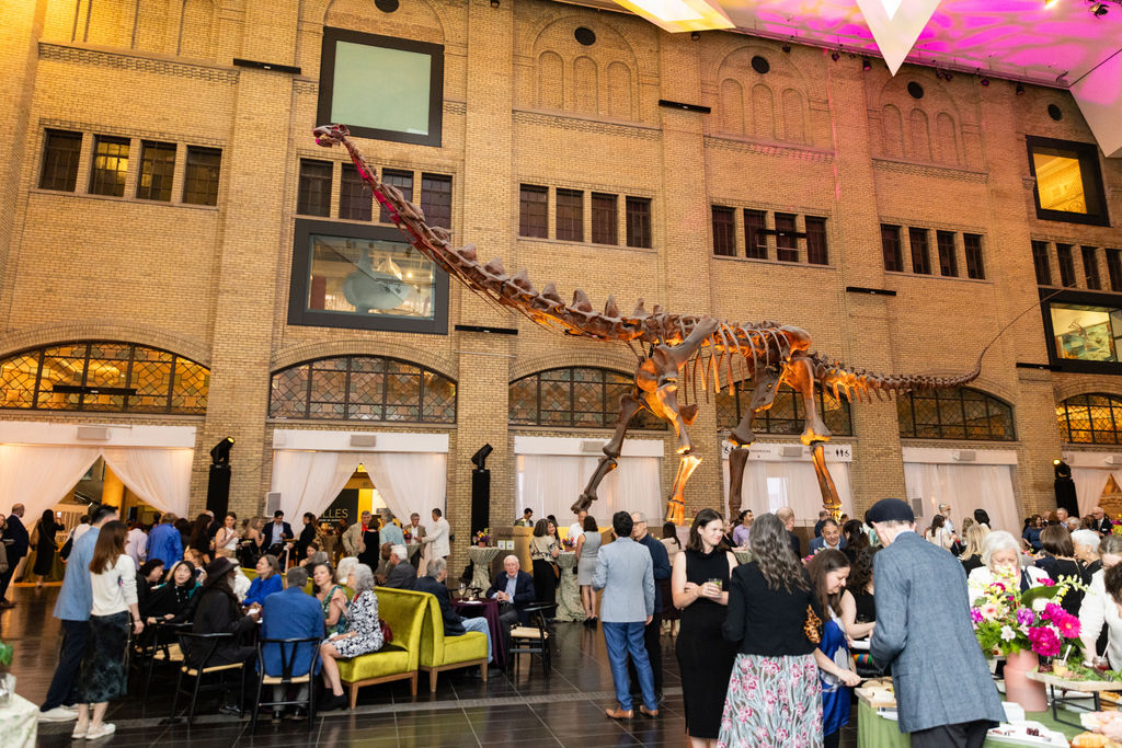 Guests gather beneath a towering Barosaurus skeleton in the Royal Ontario Museum's Samuel Hall Currelly Gallery during ROM Celebration 2026.