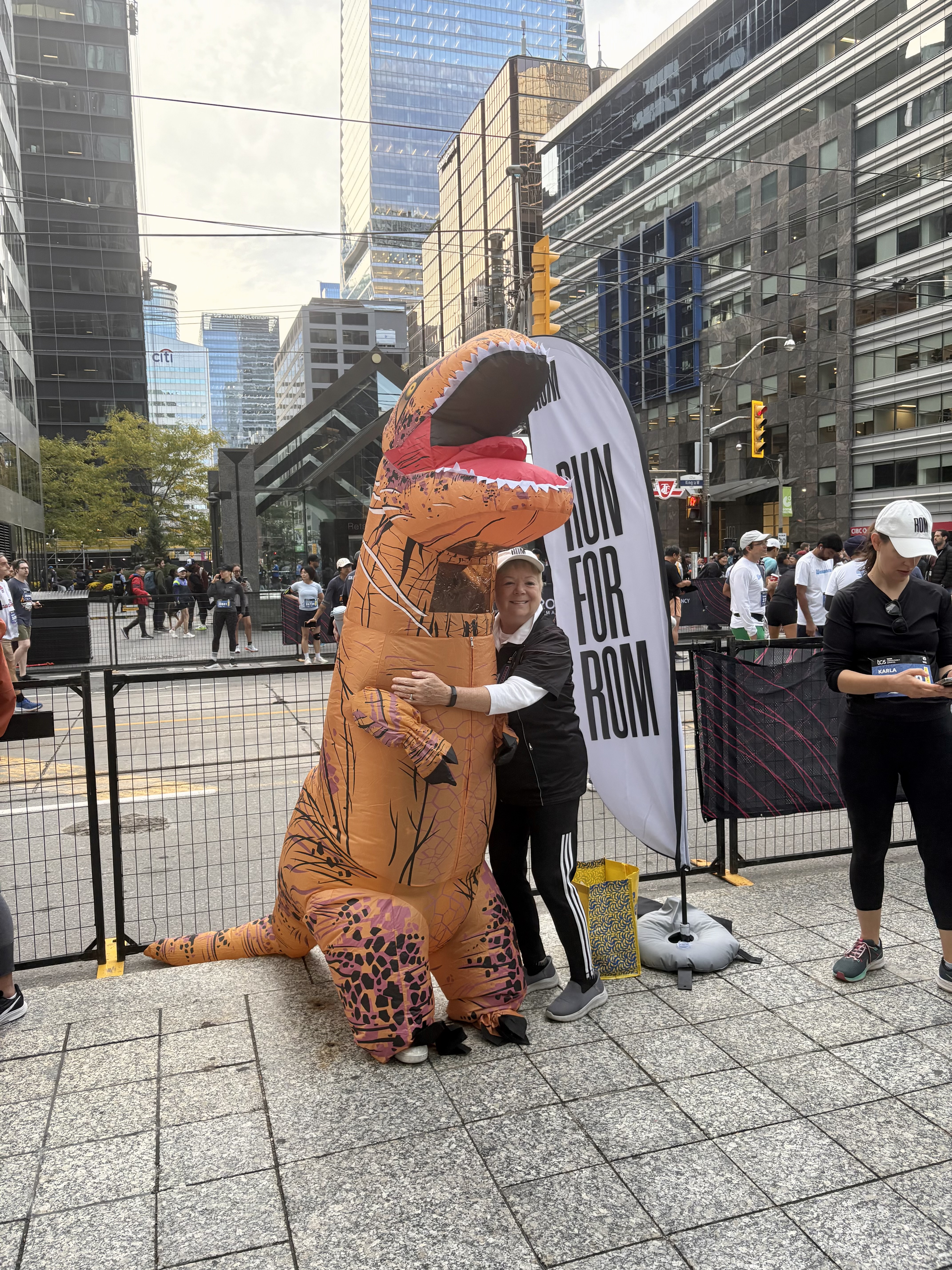 Janice Price, President and CEO of ROM Governors hugging the Run for ROM mascot prior to running in the 5K. 