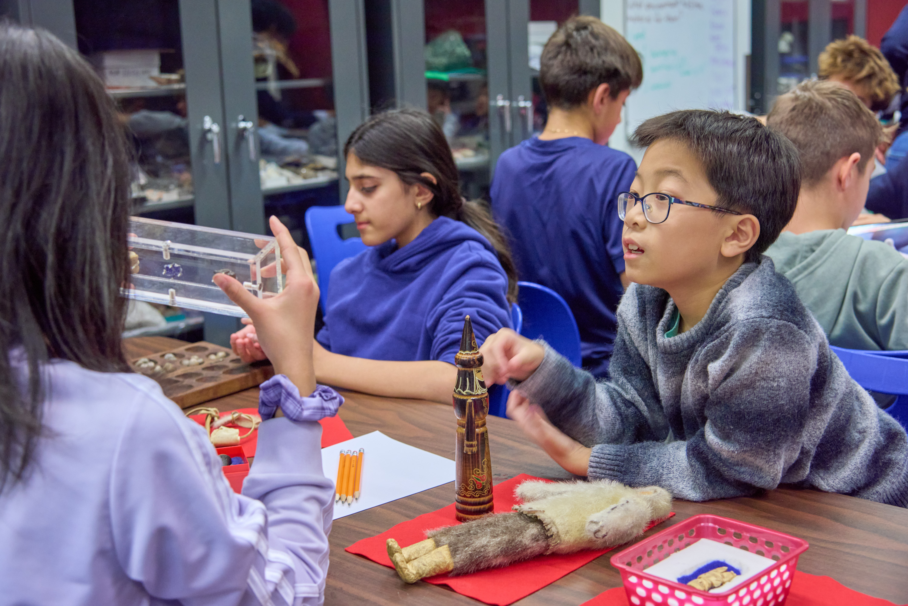 Students handle objects in a classroom