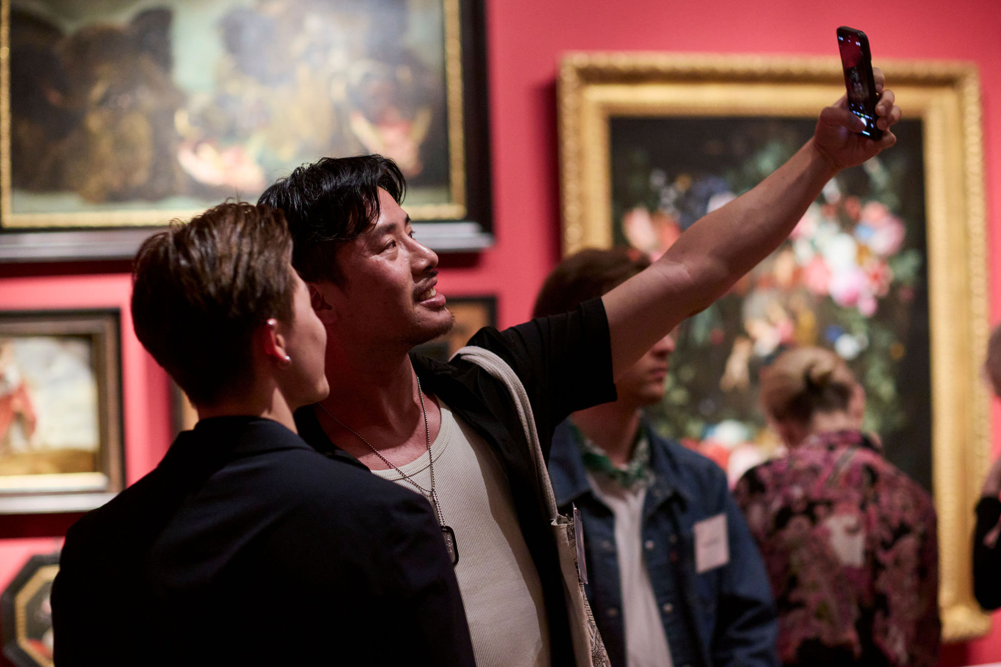 Patrons taking a selfie at an exhibition opening