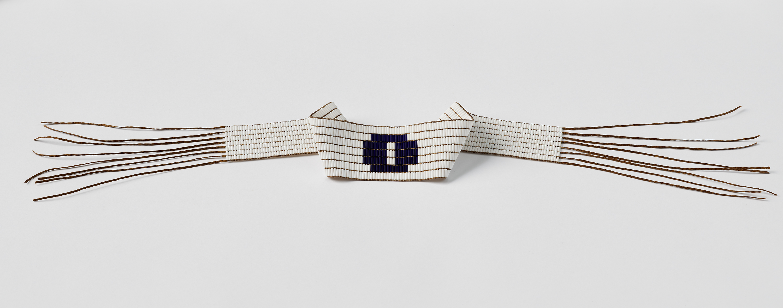 a white beaded belt with a purple circle