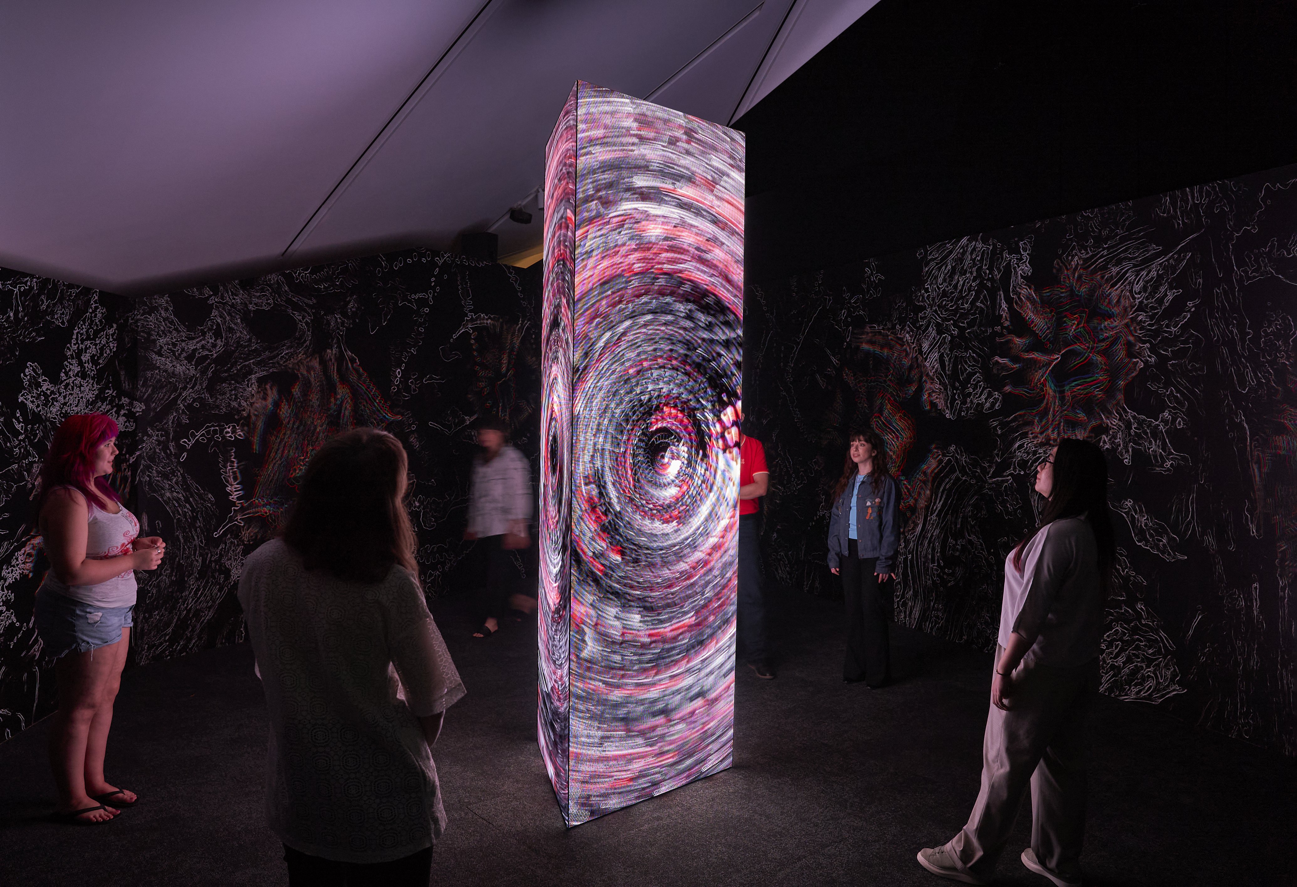 image of people looking at video monolith inside exhibition