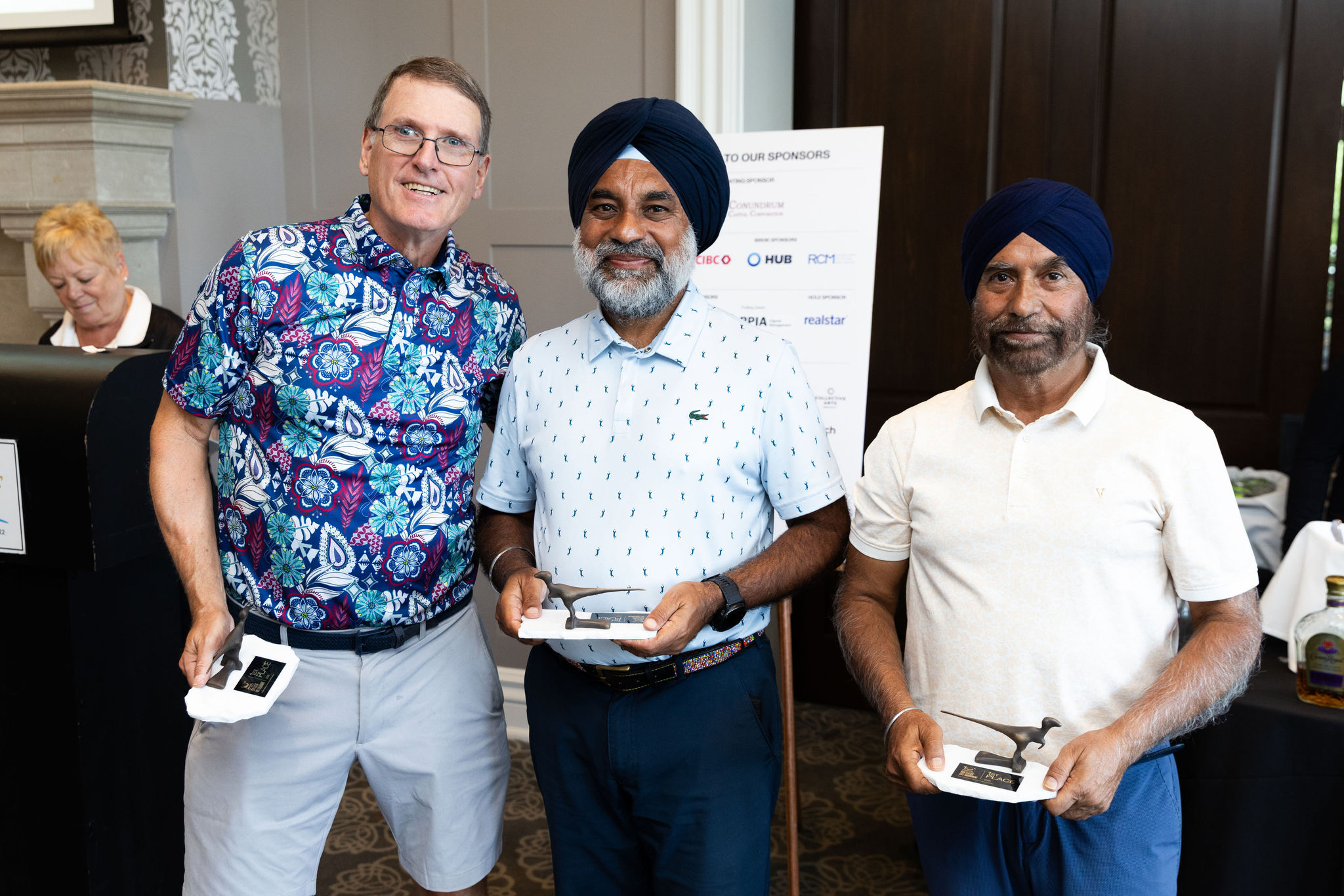 Three men holding the Raptors 1st place trophies.