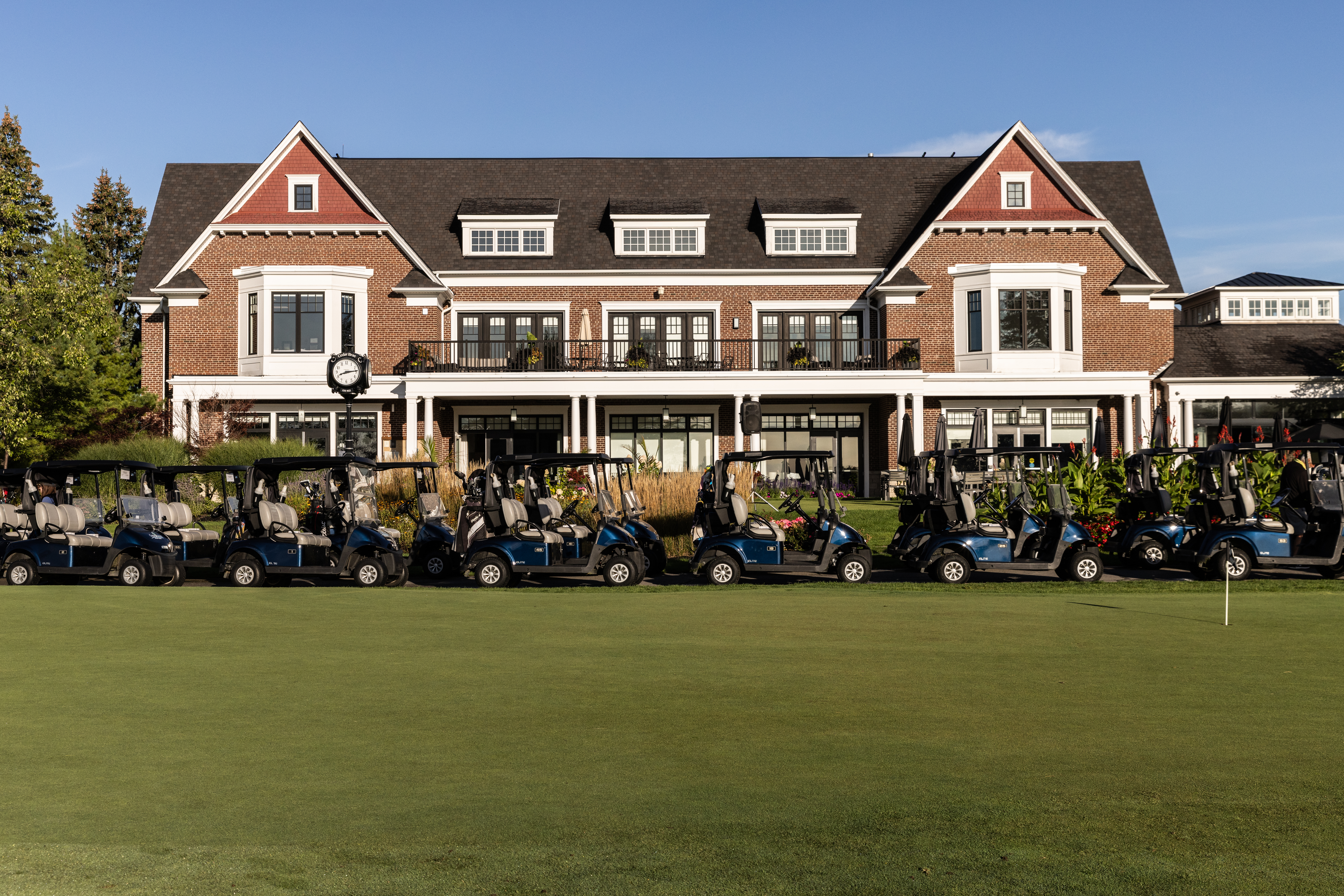 Cedar Brae golf club with player golf carts parked in front. 
