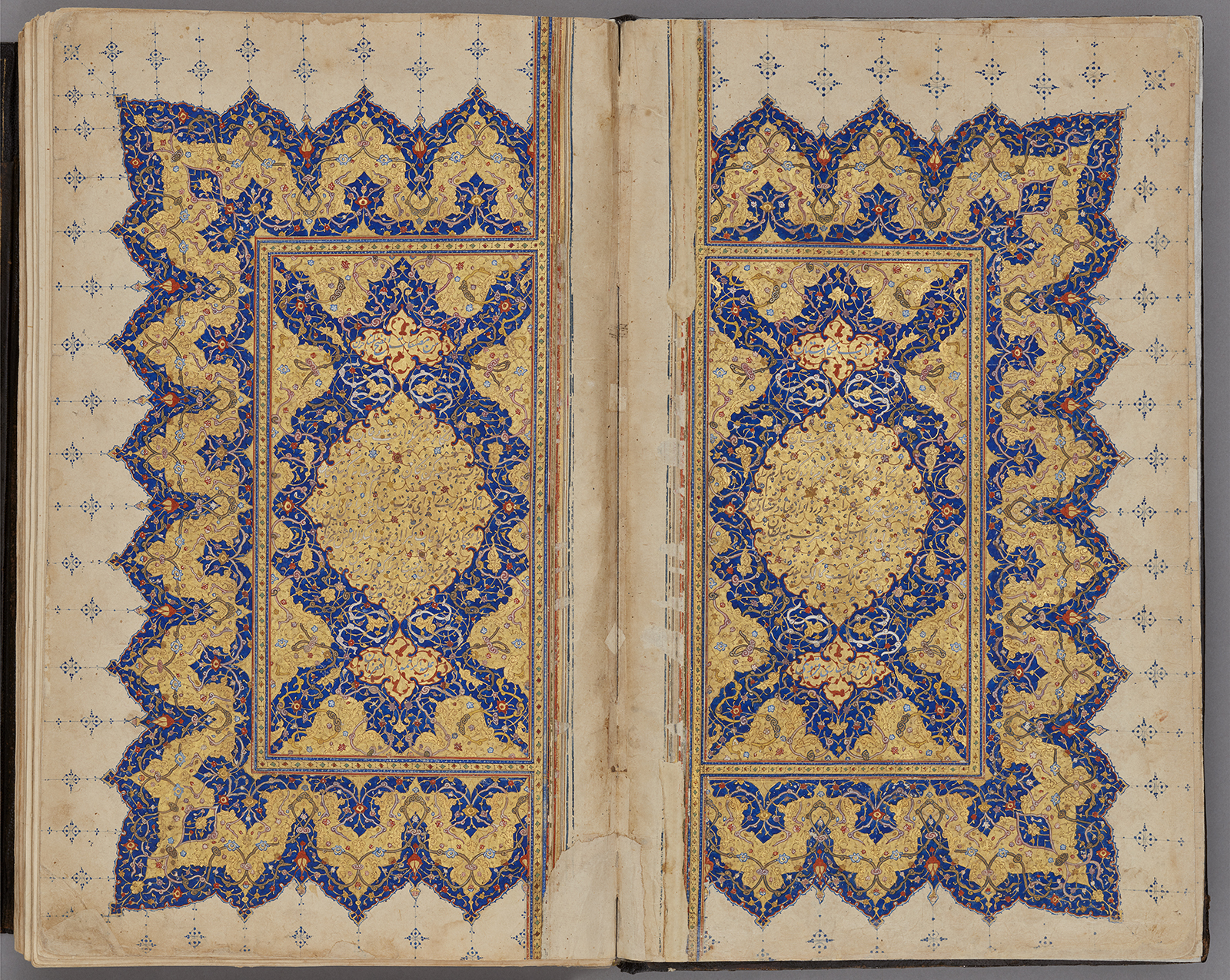 A book page covered in intricate geometric blue and red illumination with red accents.