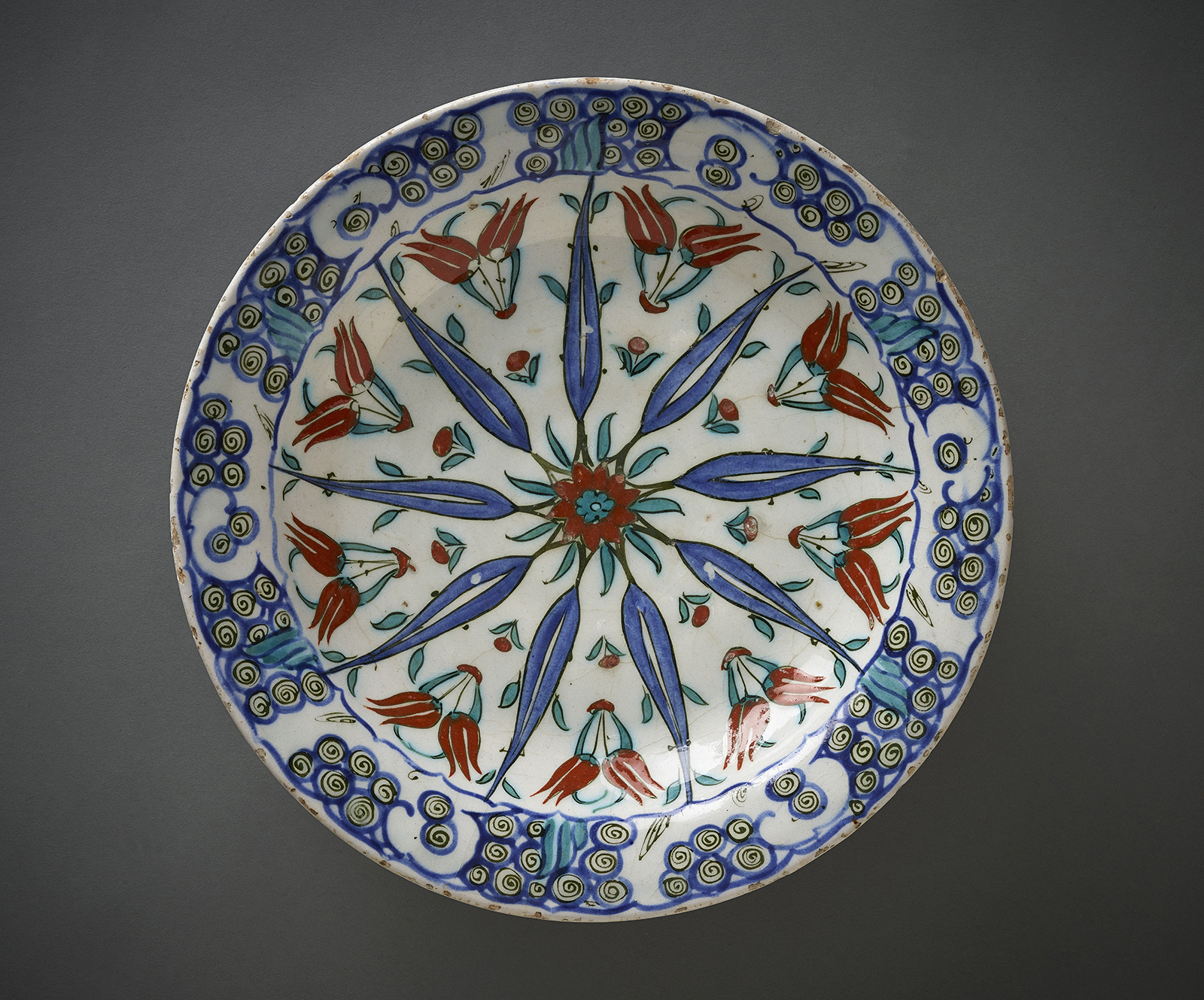 A dish featuring a radial geometric design featuring tulips.