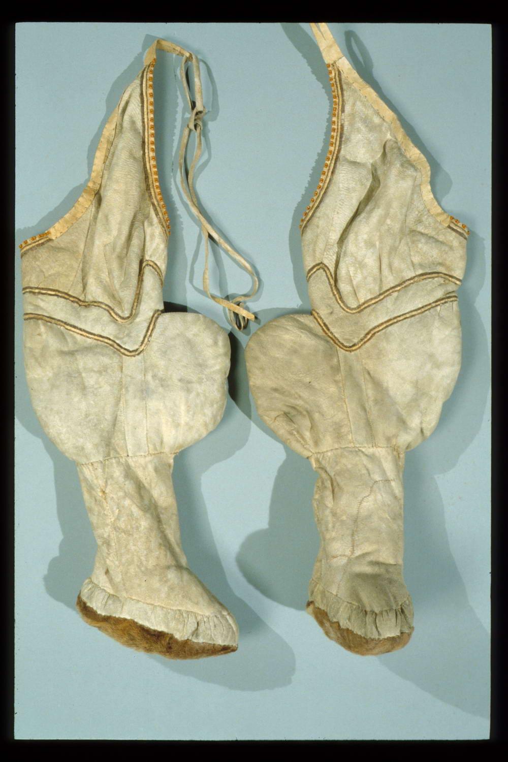 Light brown caribou-skin leggings with furred soles and decorative stitching around the thigh area, which is much less fitted than the boot portion of the leggings.