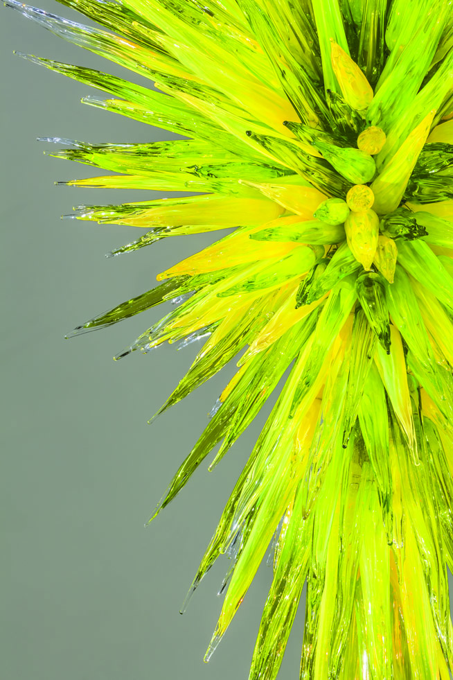 A green glass sculpture with sharp points coming out of the centre