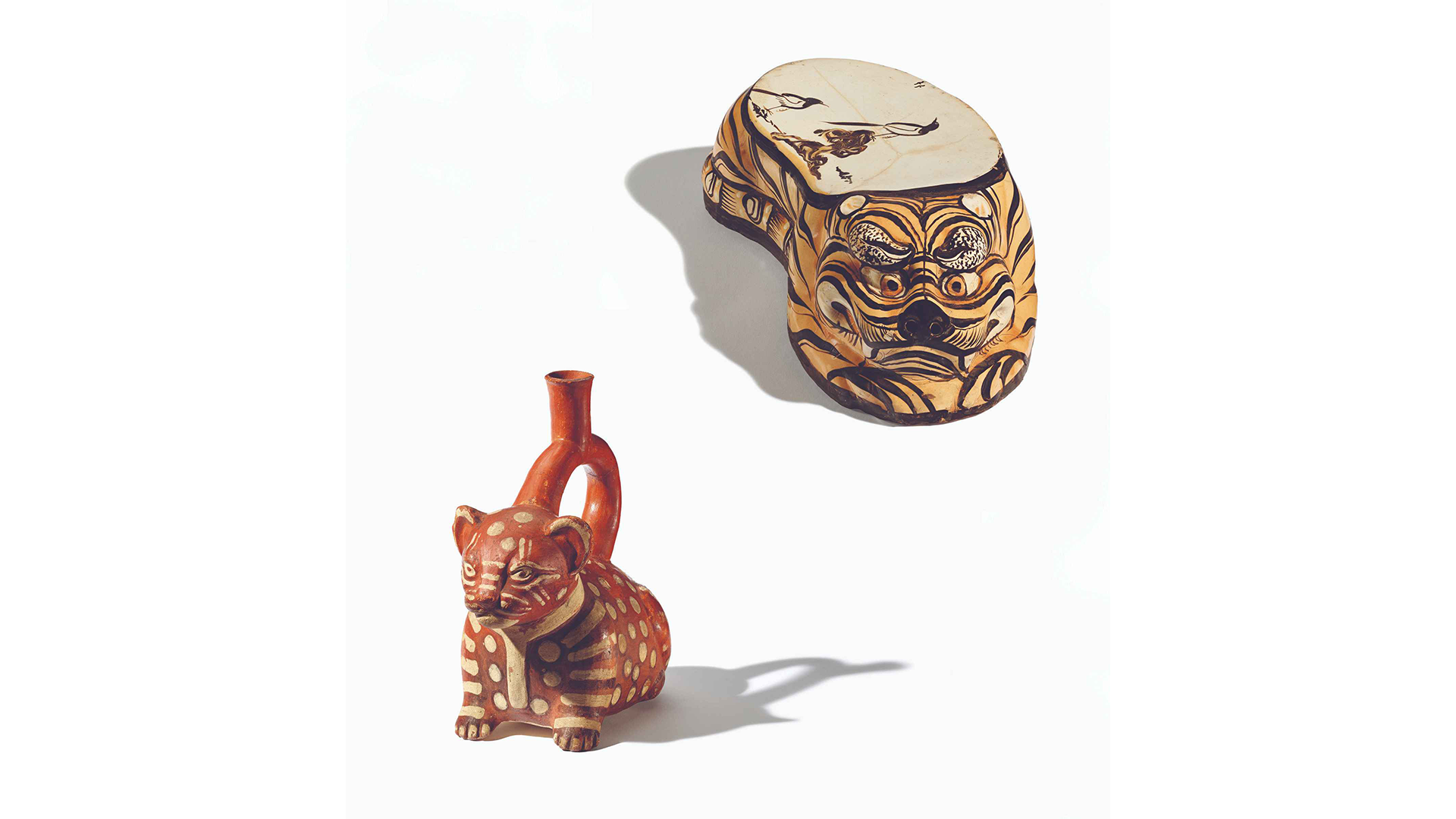 Photos of a pillow in tiger form and a stirrup spout vessel in the form of a seated cat.
