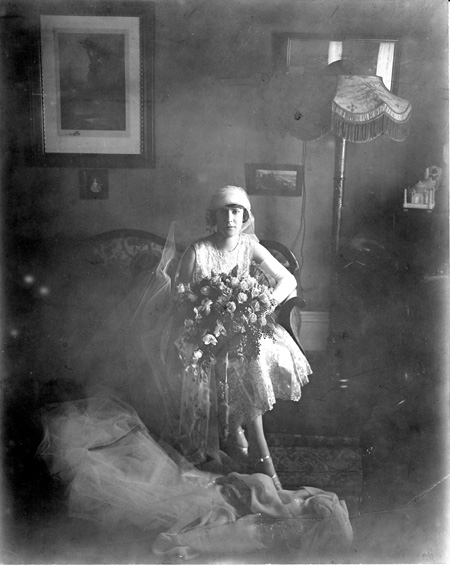 Portrait of bride sitting on sofa.