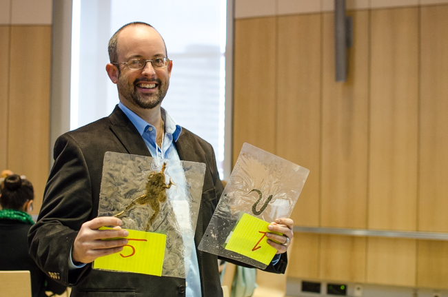 Road ecology conference moderator Brad Steinberg of the OMNR holds up thelaminated roadkill time warning signs he made for the speakers