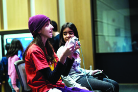 two girl testing out a video game designed for the ROM's Game Jam