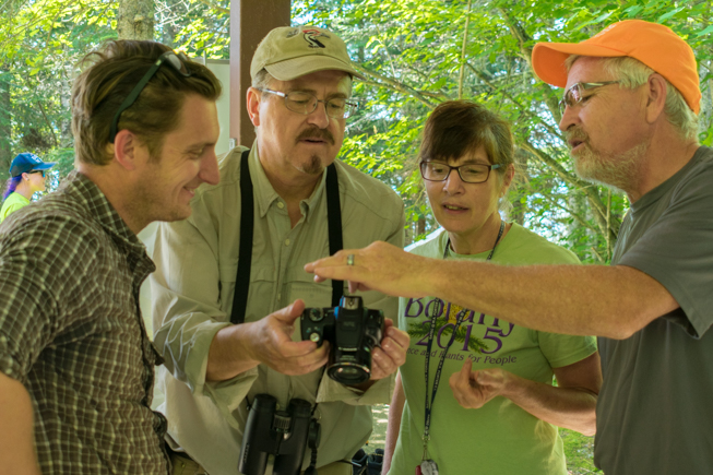 ROM biologists check out a photo with Jim Mackenzie, Coordinator of Ontario Natural Heritage Information Centre at Ministry of Natural Resources and Forestry. Photo by Adil Darvesh