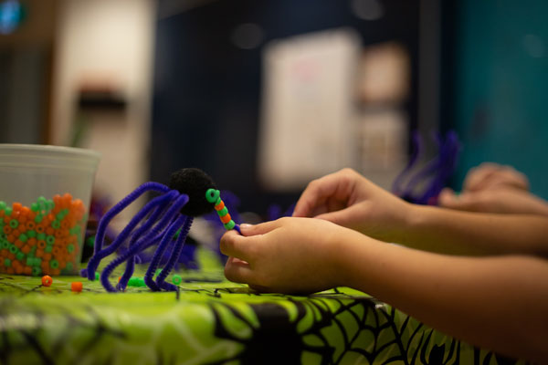A child at the Hospital for Sick Children enjoys a spider themed craft