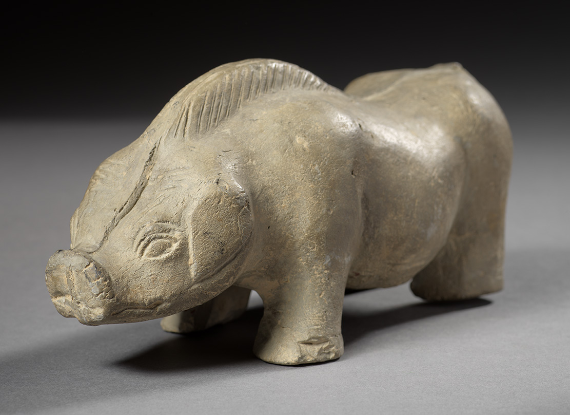 Une figurine brune représentant un cochon debout sur ses quatre pattes