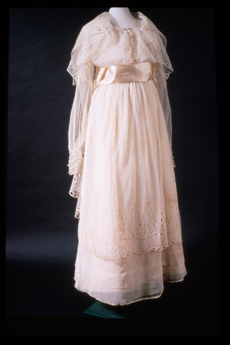 White dress hanging on form in photo studio.