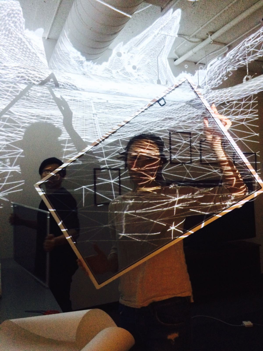 a student holding up a frame with dramatic lighting 