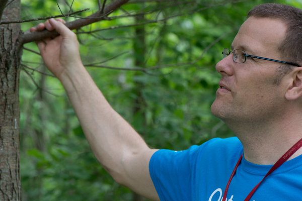 Troy McMullin is examining some lichens at Baker’s Woods. He thinks “there might be more to Toronto’s lichen story than meets the eye” Photo by Austin Miller